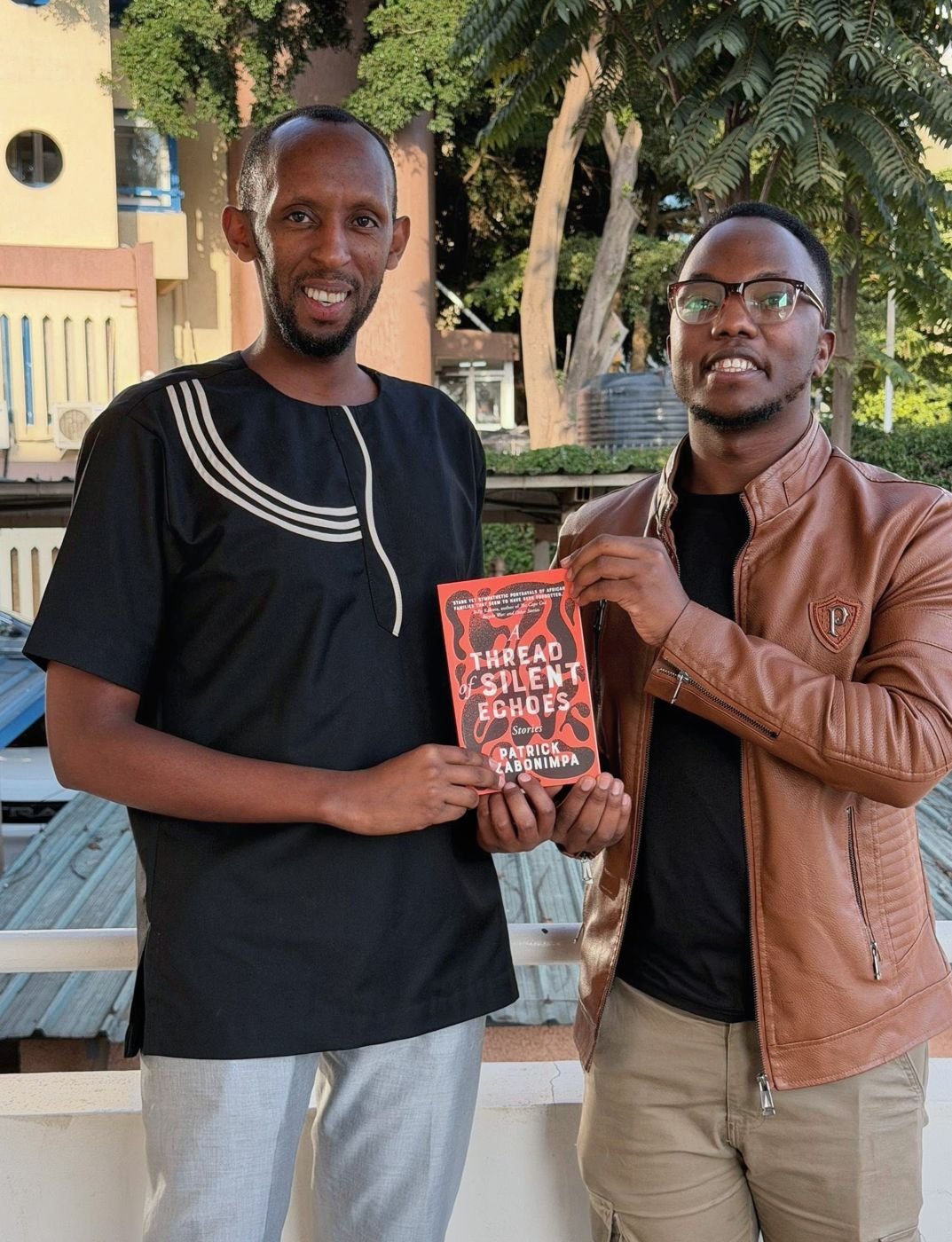 Two readers on a balcony with the book