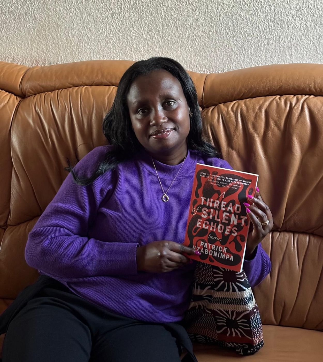 A reader on a sofa holding the book
